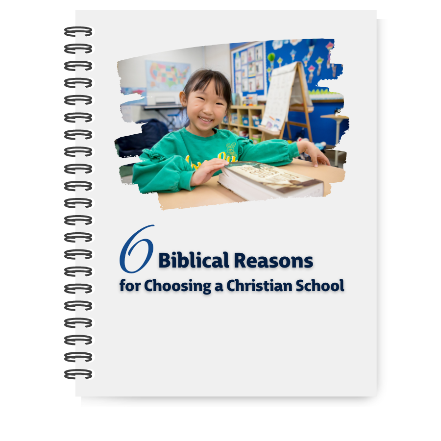 Biblical Reasons for Choosing a Christian School cover photo with young girl at desk smiling and reading open Bible